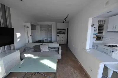 a living room with a couch and a table at Atico Apartamento Loft Playa Victoria Cadiz in Cádiz