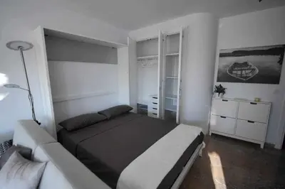 a bedroom with a bed and a couch at Atico Apartamento Loft Playa Victoria Cadiz in Cádiz