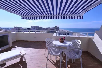 a balcony with a table and chairs and the ocean at Atico Apartamento Loft Playa Victoria Cadiz in Cádiz