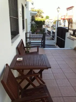 a wooden table and two chairs on a patio at Hostal Victoria Mar in Chipiona