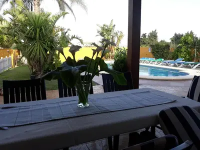a vase of flowers on a table with a table cloth at Chalet la Huerta con piscina y wifi in Conil de la Frontera