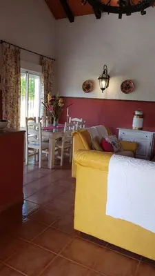 a living room with a yellow couch and a table at Chalet la Huerta con piscina y wifi in Conil de la Frontera