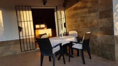 a dining room with a table and four chairs at Chalet la Huerta con piscina y wifi in Conil de la Frontera