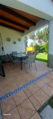 a patio with a table and chairs on a patio at Chalet la Huerta con piscina y wifi in Conil de la Frontera