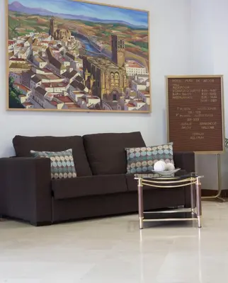 a living room with a couch and a painting on the wall at Hotel Peña de Arcos in Arcos de la Frontera