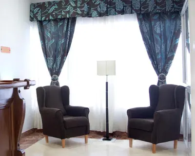 two chairs and a lamp in front of a window at Hotel Peña de Arcos in Arcos de la Frontera