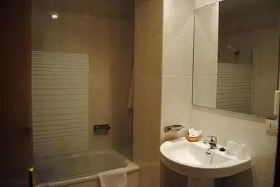 a bathroom with a sink and a mirror and a tub at Hotel Peña de Arcos in Arcos de la Frontera