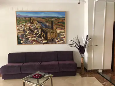 a living room with a couch and a painting on the wall at Hotel Peña de Arcos in Arcos de la Frontera