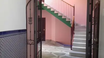 a staircase in a house with a green and pink wall at Piso en centro histórico in Jerez de la Frontera