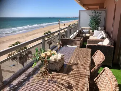 a balcony with tables and chairs and the beach at Luxury Oceanfront triplex in Cadiz in Cádiz