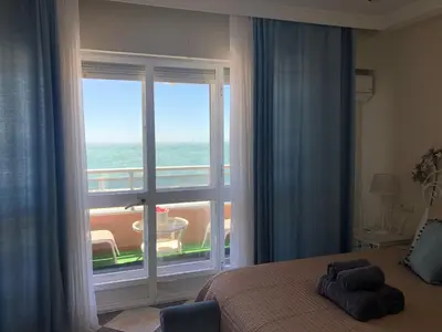 a bedroom with a large window with a view of the ocean at Luxury Oceanfront triplex in Cadiz in Cádiz