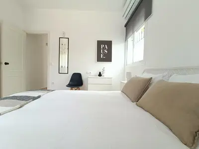 a white bedroom with a large white bed at Moderno Apartamento junto a la Playa in Sanlúcar de Barrameda