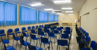 an empty room with blue chairs and windows at Albergue Inturjoven Jerez De La Frontera in Jerez de la Frontera