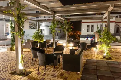 a restaurant with chairs and tables on a patio at night at Albergue Inturjoven Chipiona in Chipiona