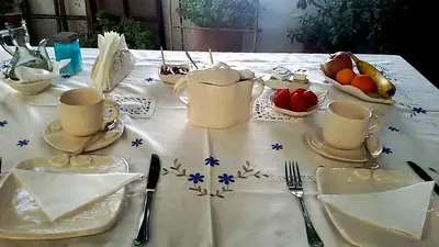 a table with a white table cloth with plates and utensils at La Casa de Bovedas Charming Inn in Arcos de la Frontera