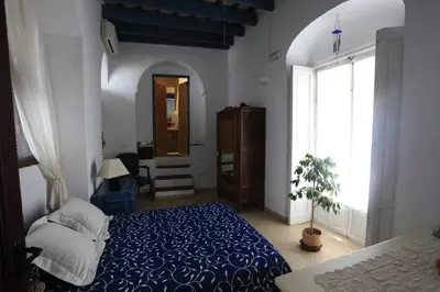a bedroom with a blue bed and a window at La Casa de Bovedas Charming Inn in Arcos de la Frontera