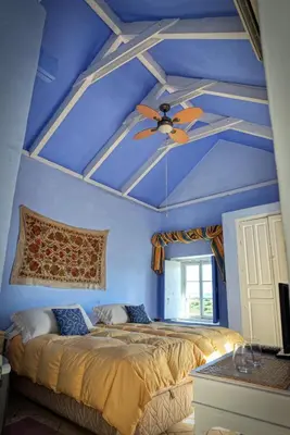 a bedroom with a ceiling fan and blue walls at La Casa de Bovedas Charming Inn in Arcos de la Frontera