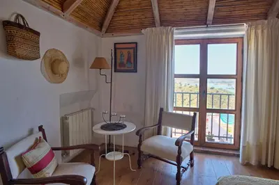 a living room with a table and chairs and a window at La Casa de Bovedas Charming Inn in Arcos de la Frontera