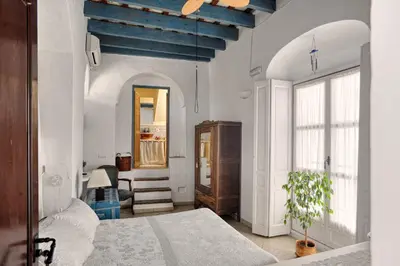 a bedroom with a bed and a blue ceiling at La Casa de Bovedas Charming Inn in Arcos de la Frontera
