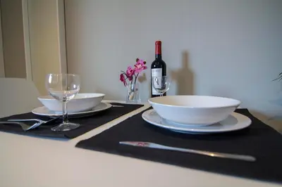 a table with two plates and glasses and a bottle of wine at estudio santa maria in El Puerto de Santa María