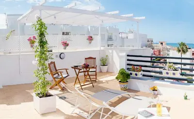 a balcony with chairs and a table on a building at Summerland Apartments Rota in Rota