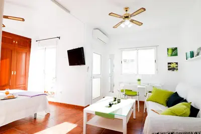 a living room with white furniture and a ceiling fan at Summerland Apartments Rota in Rota