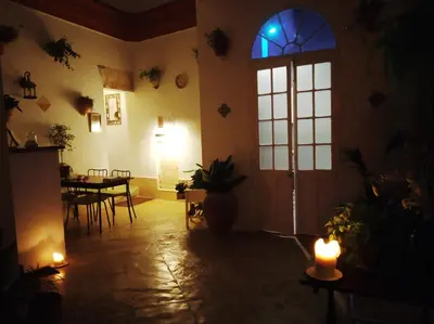 a dark room with a window and a table with candles at Casa Campana in Arcos de la Frontera