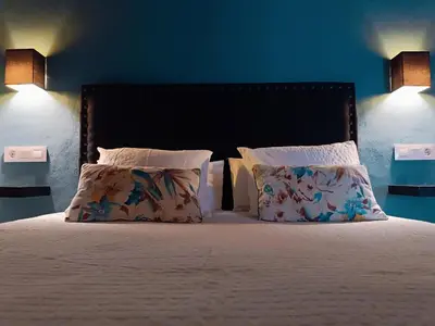 a bedroom with a bed with two pillows and two lamps at Casa Campana in Arcos de la Frontera