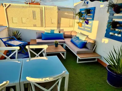 a patio with a couch and a table and chairs at Ático con Encanto in Sanlúcar de Barrameda