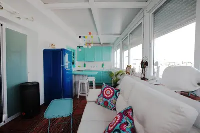 a living room with a white couch and blue cabinets at Ático con Encanto in Sanlúcar de Barrameda
