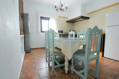 a kitchen with a table and chairs in a kitchen at Villa Rocío-Conil in Conil de la Frontera