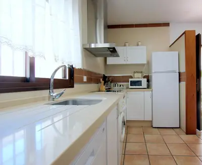 a kitchen with a sink and a white refrigerator at Villa Rocío-Conil in Conil de la Frontera