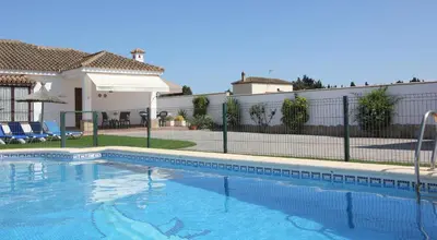 a swimming pool in front of a house at Villa Rocío-Conil in Conil de la Frontera