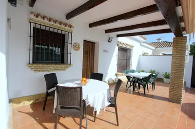 a dining room with a table and chairs on a patio at Villa Rocío-Conil in Conil de la Frontera