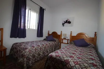 a bedroom with two beds and a window at Casa Melli in Conil de la Frontera