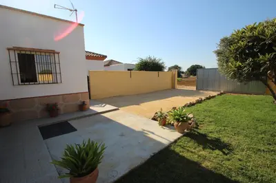 a backyard of a house with a yard with potted plants at Casa Melli in Conil de la Frontera