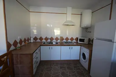 a kitchen with a refrigerator and a washing machine at Casa Melli in Conil de la Frontera