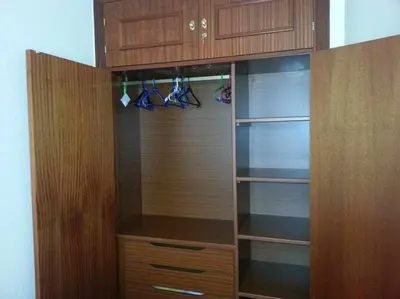 a closet with wooden cabinets and shoes in it at Enjoy Life Chipiona in Chipiona