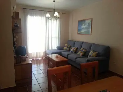 a living room with a blue couch and a table at Enjoy Life Chipiona in Chipiona