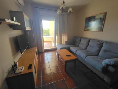 a living room with a blue couch and a table at Enjoy Life Chipiona in Chipiona