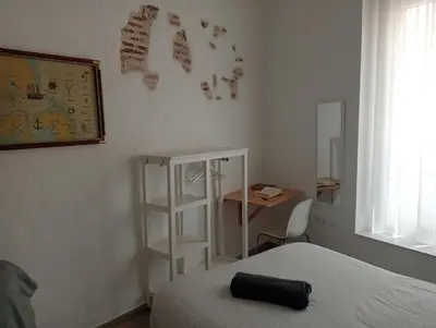a bedroom with a bed and a desk and a shelf at La Caleta de Cadiz WiFi in Cádiz