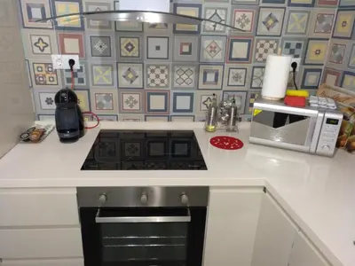 a kitchen with a stove and a microwave at La Caleta de Cadiz WiFi in Cádiz