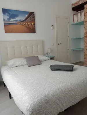 a white bed with a pillow on top of it at La Caleta de Cadiz WiFi in Cádiz