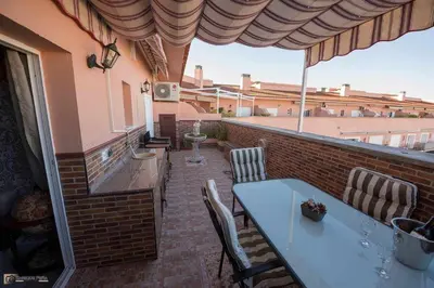 a patio with a table and chairs on a brick wall at Ático Las Infantas- Parking gratuito in Sanlúcar de Barrameda