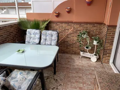 a patio with a table and some potted plants at Ático Las Infantas- Parking gratuito in Sanlúcar de Barrameda