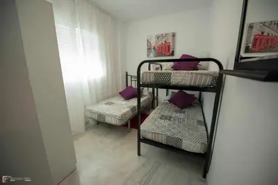 two bunk beds in a small room with a window at Ático Las Infantas- Parking gratuito in Sanlúcar de Barrameda