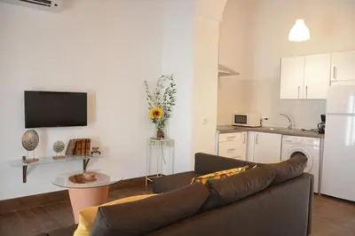 a living room with a couch and a kitchen at Casa Rural Pueblos Blancos in Bornos