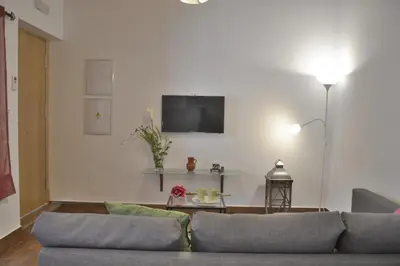 a living room with a couch and a tv on a wall at Casa Rural Pueblos Blancos in Bornos
