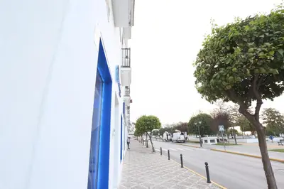 a blue flag on the side of a building with a sidewalk at Apartamento Duque de Arcos 2 in Arcos de la Frontera