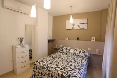 a bedroom with a bed and a dresser in it at Apartamento Duque de Arcos 2 in Arcos de la Frontera